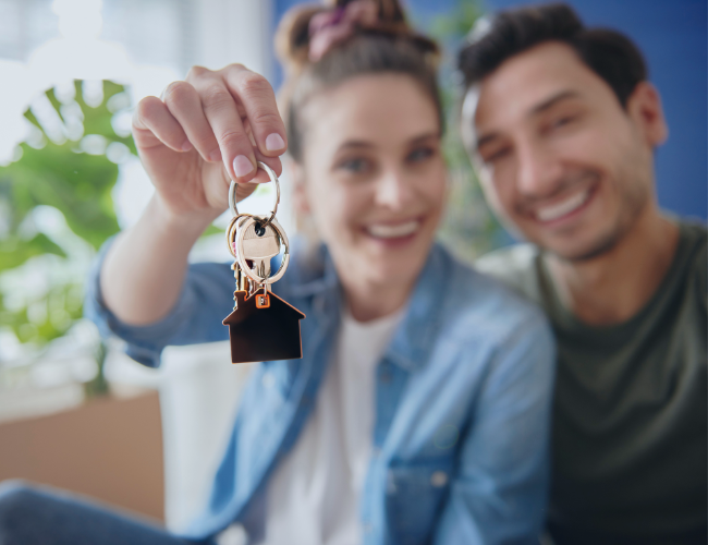 Pareja feliz con las llaves de su vivienda nueva en Talagante, gracias al subsidio al crédito hipotecario del Minvu.